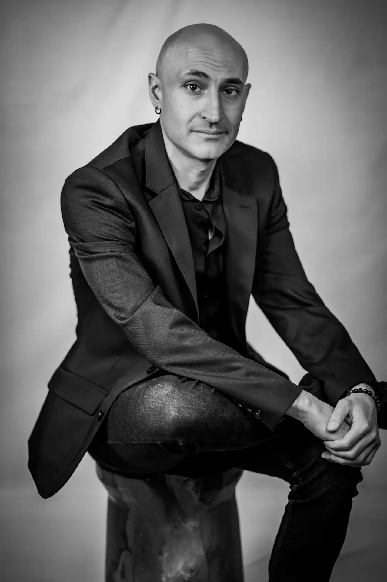 Jason Bekdashe, seated in a dark suit, black-and-white studio portrait